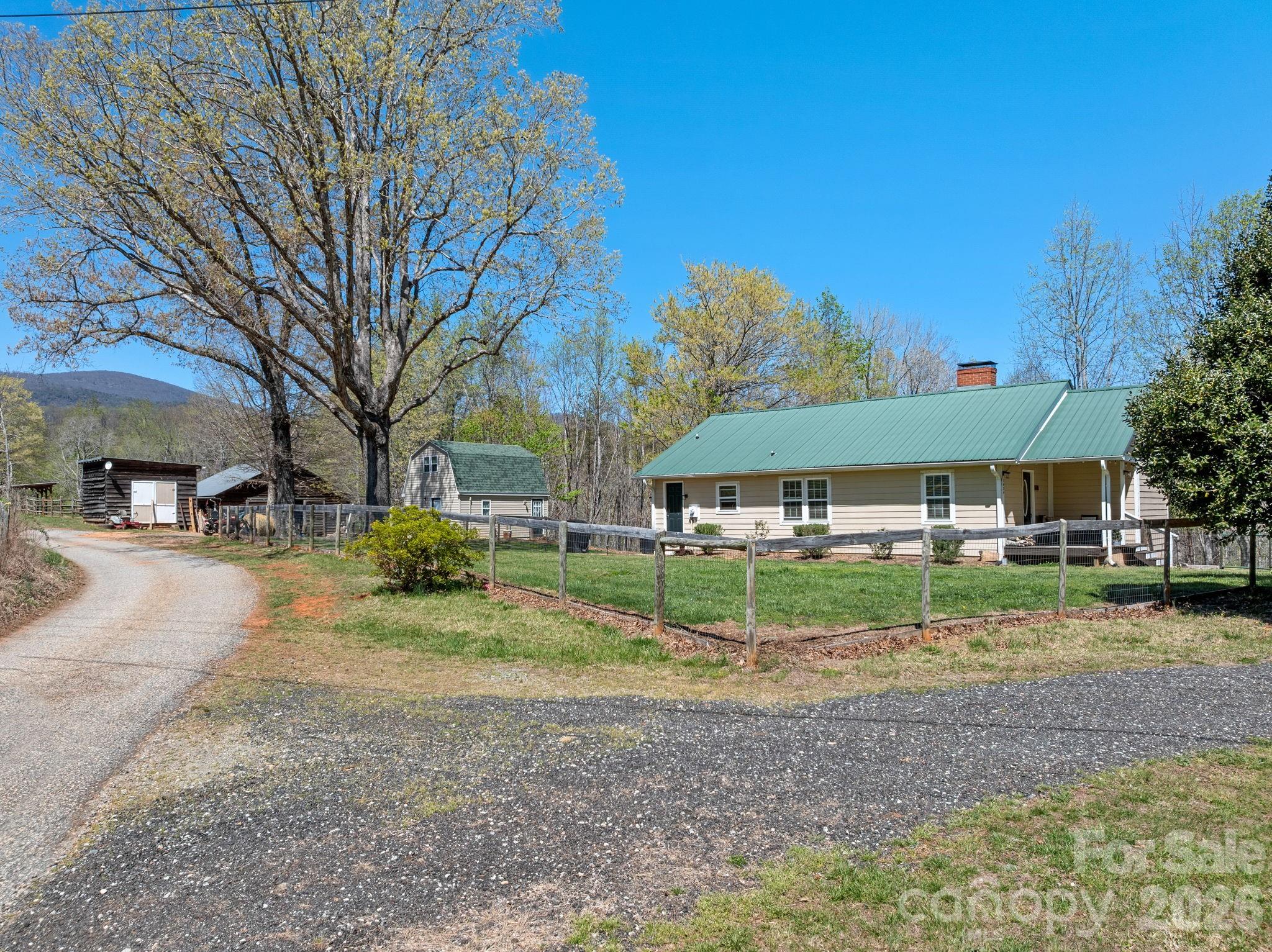 1434 Lake Adger Road Mill Spring, NC 28756 - Photo 5 of 47 a backyard of a house with barbeque oven table and chairs
