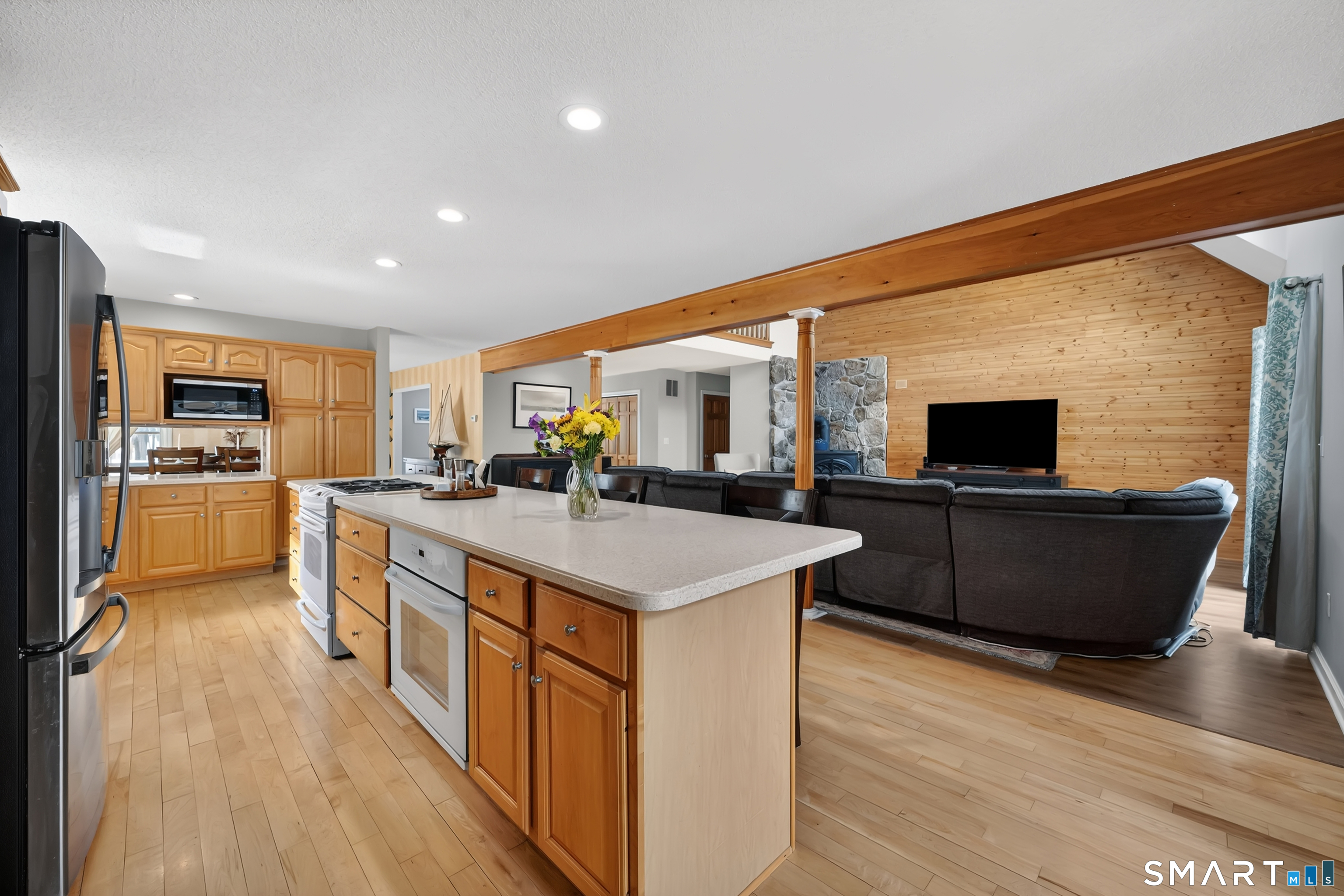 a large kitchen with stainless steel appliances kitchen island granite countertop a large counter top and a stove top oven