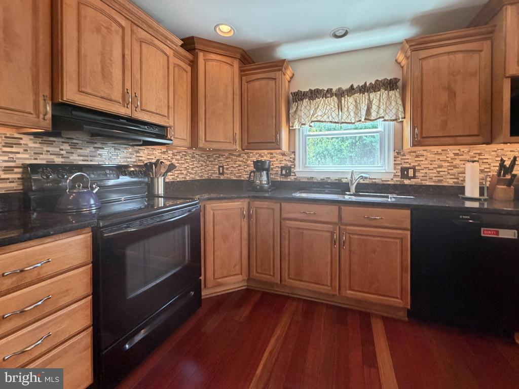 925 Big Oak Road Yardley, PA 19067 - Photo 16 of 51 a kitchen with stainless steel appliances granite countertop wooden cabinets a sink and dishwasher with wooden floor
