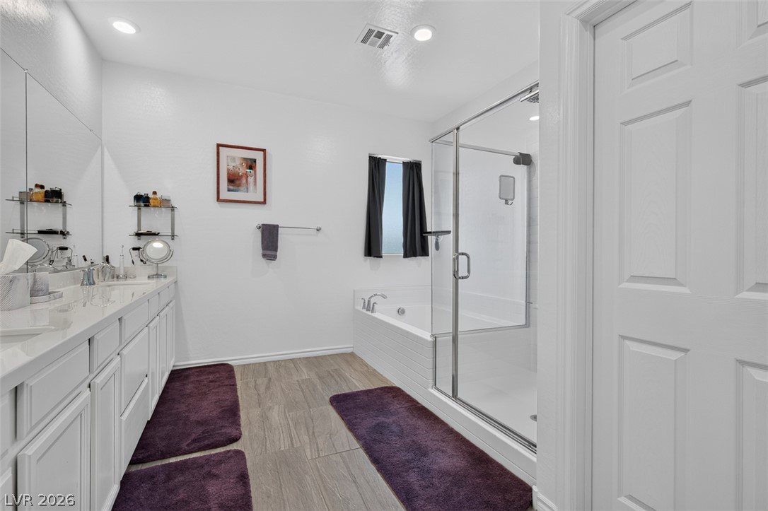 1824 Redland Ridge Street Henderson, NV 89002 - Photo 39 of 69 A well-appointed bathroom offers a dual vanity, sleek glass shower, and a pristine soaking tub.