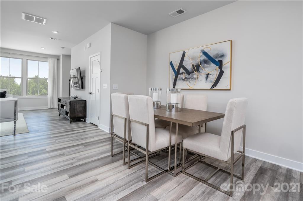 957 Portrush Lane, Unit 1010D Tega Cay, SC 29708 - Photo 7 of 13 a view of a dining room with furniture window and wooden floor