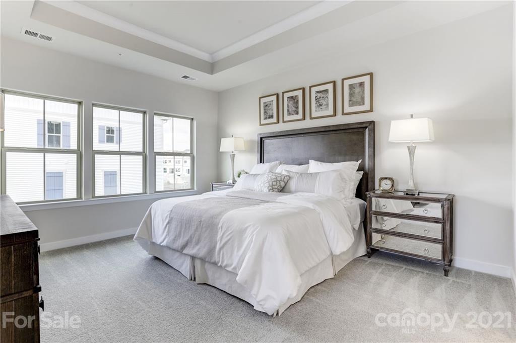 957 Portrush Lane, Unit 1010D Tega Cay, SC 29708 - Photo 9 of 13 a spacious bedroom with a bed and a large window