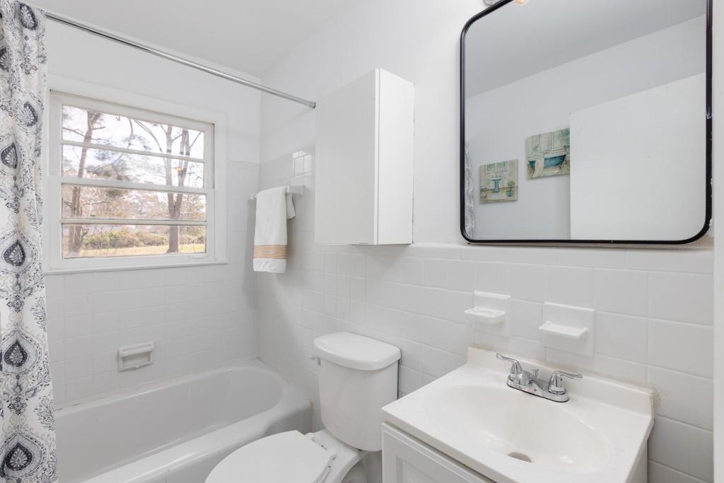 282 Willis Mill Road Southwest Atlanta, GA 30311 - Photo 16 of 25 a bath room with a toilet a sink and a bath tub