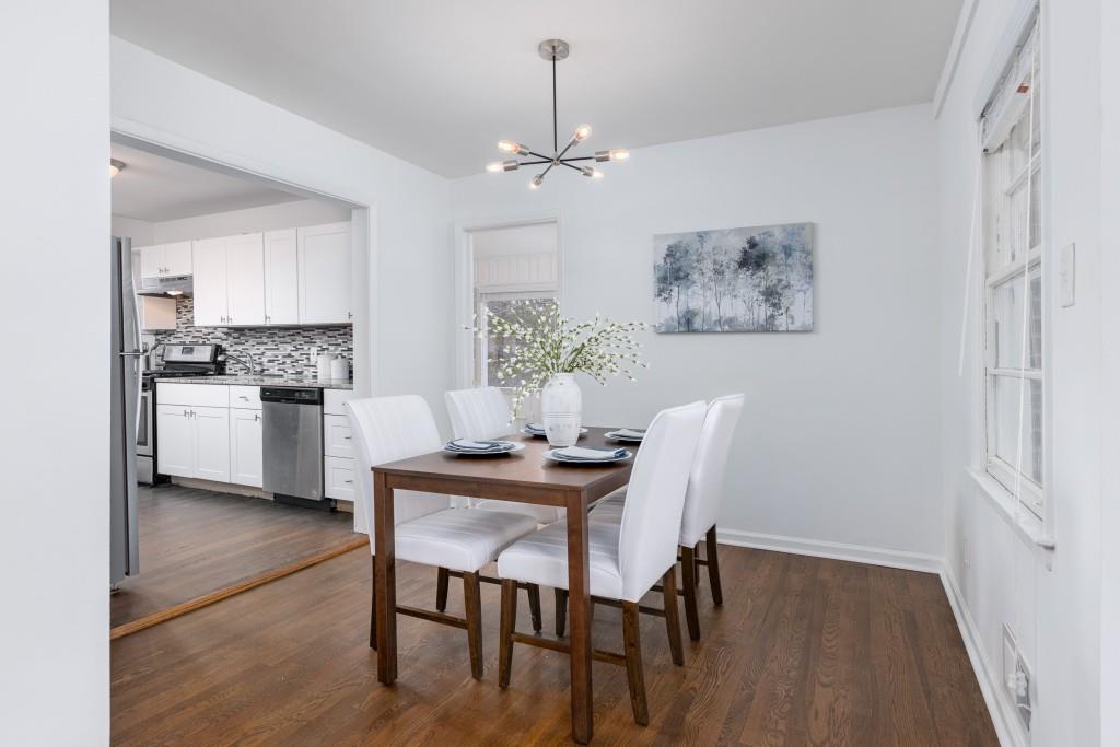 282 Willis Mill Road Southwest Atlanta, GA 30311 - Photo 7 of 25 a dining room with wooden floor a chandelier a wooden table and chairs