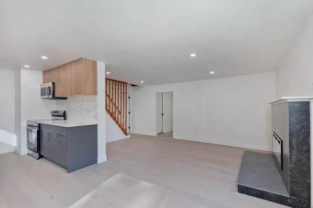 a view of kitchen with stainless steel appliances granite countertop refrigerator sink and stove