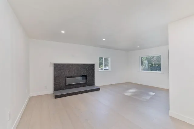 an empty room with a fireplace and window