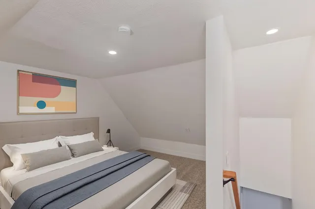 a bedroom with a bed and a painting on the wall