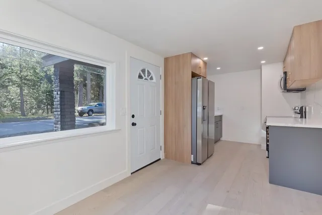 a view of kitchen with stainless steel appliances granite countertop a refrigerator and a sink