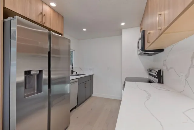 a kitchen with stainless steel appliances a refrigerator and a sink