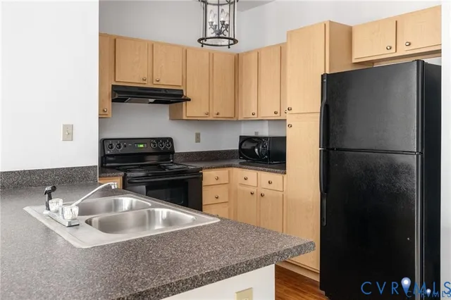 a kitchen with stainless steel appliances granite countertop a sink a refrigerator a stove a microwave and cabinets