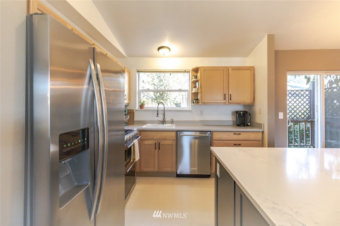 2829 Northeast 4th Court Renton, WA 98056 - Photo 3 of 26 a kitchen with stainless steel appliances granite countertop a sink a stove and a refrigerator