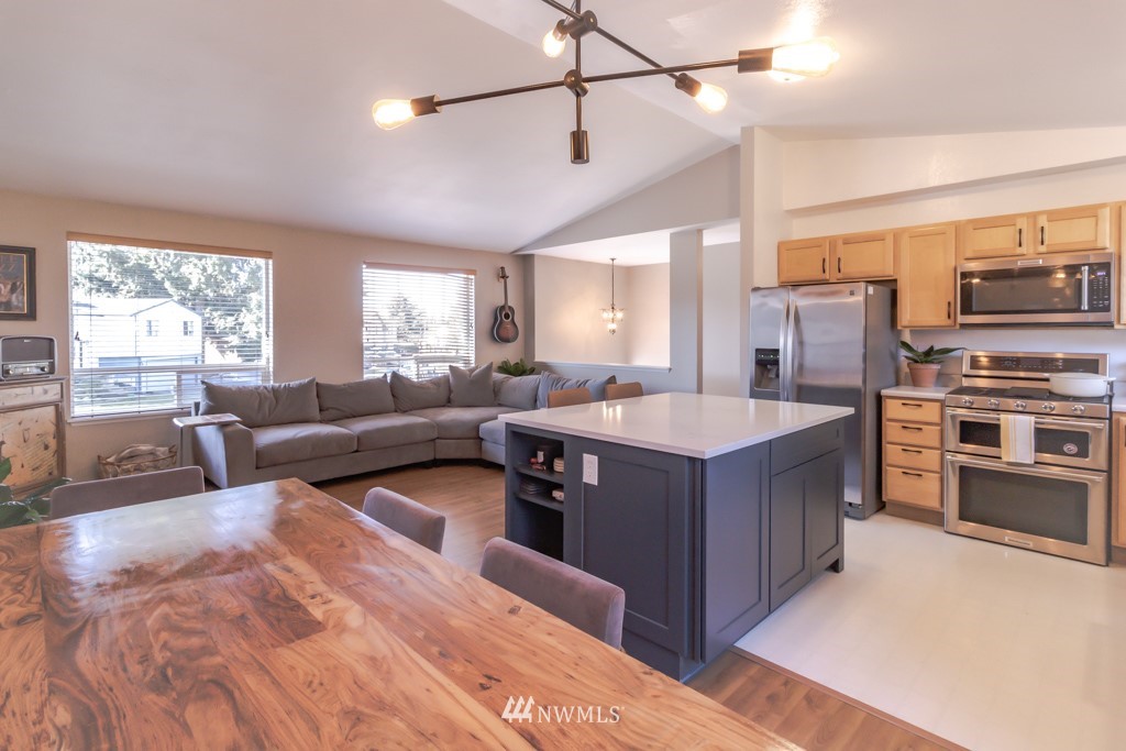 2829 Northeast 4th Court Renton, WA 98056 - Photo 5 of 26 a kitchen with a stove kitchen island and couches with wooden floor
