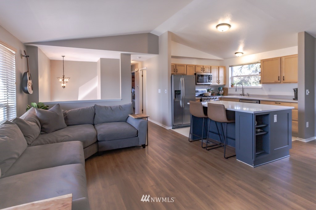2829 Northeast 4th Court Renton, WA 98056 - Photo 7 of 26 a living room with stainless steel appliances granite countertop furniture wooden floor and a view of kitchen