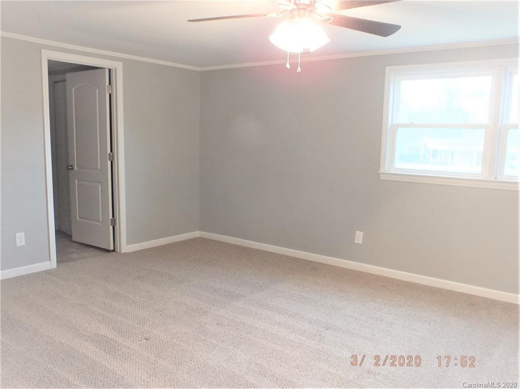 2035 Knight Road Lancaster, SC 29720 - Photo 9 of 26 an empty room with a chandelier fan and windows