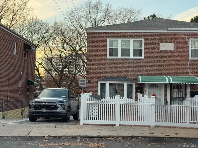 a car parked in front of a brick house