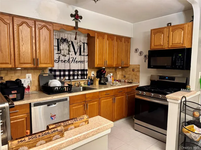 a kitchen with stainless steel appliances a stove a sink and a microwave