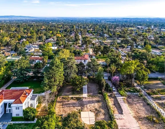 an aerial view of residential houses with outdoor space and street view