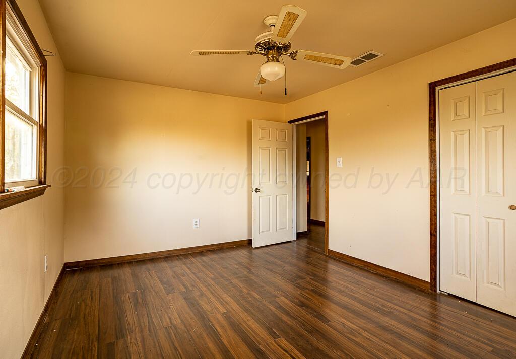 6761 County Road 11 Shamrock, TX 79079 - Photo 12 of 33 an empty room with wooden floor fan and windows