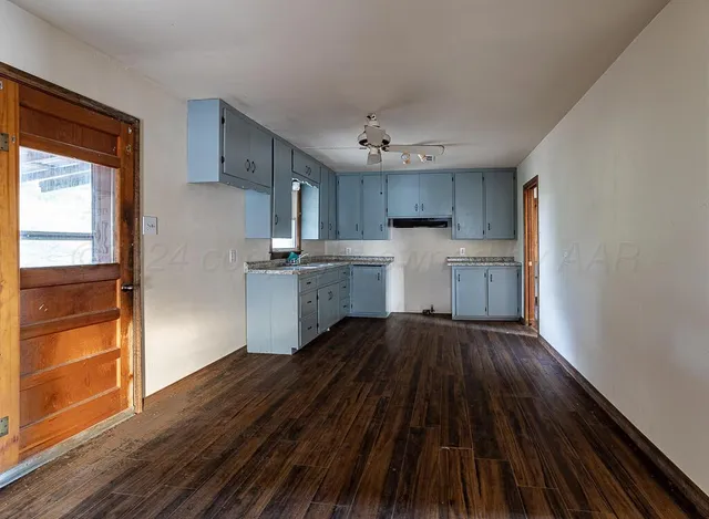 a kitchen with wooden floors and refrigerator