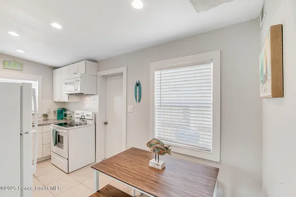 a kitchen with a refrigerator and white stove top oven