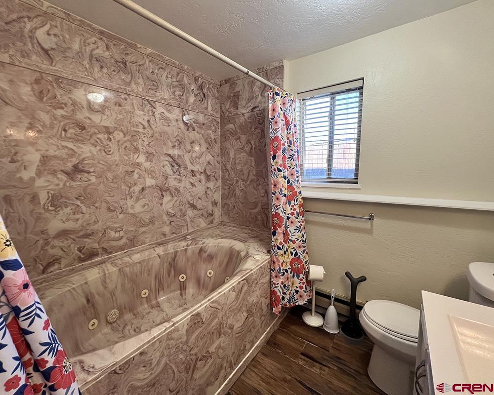 1328 Jackson Street Cortez, CO 81321 - Photo 11 of 45 a bath room with a toilet and a shower curtain