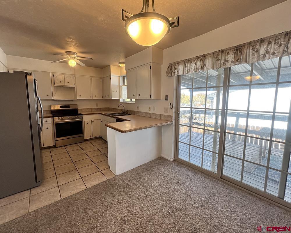1328 Jackson Street Cortez, CO 81321 - Photo 18 of 37 a kitchen with stainless steel appliances granite countertop a stove sink and refrigerator