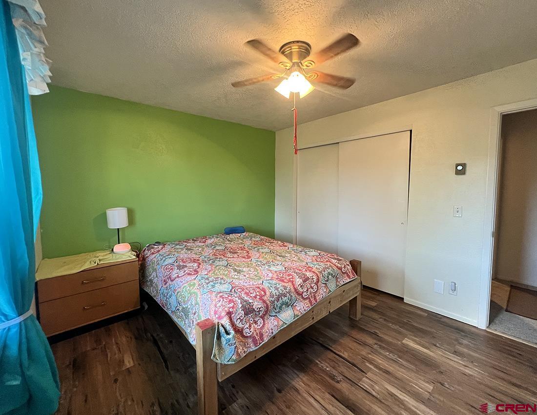 1328 Jackson Street Cortez, CO 81321 - Photo 21 of 37 a bedroom with a bed and a chandelier