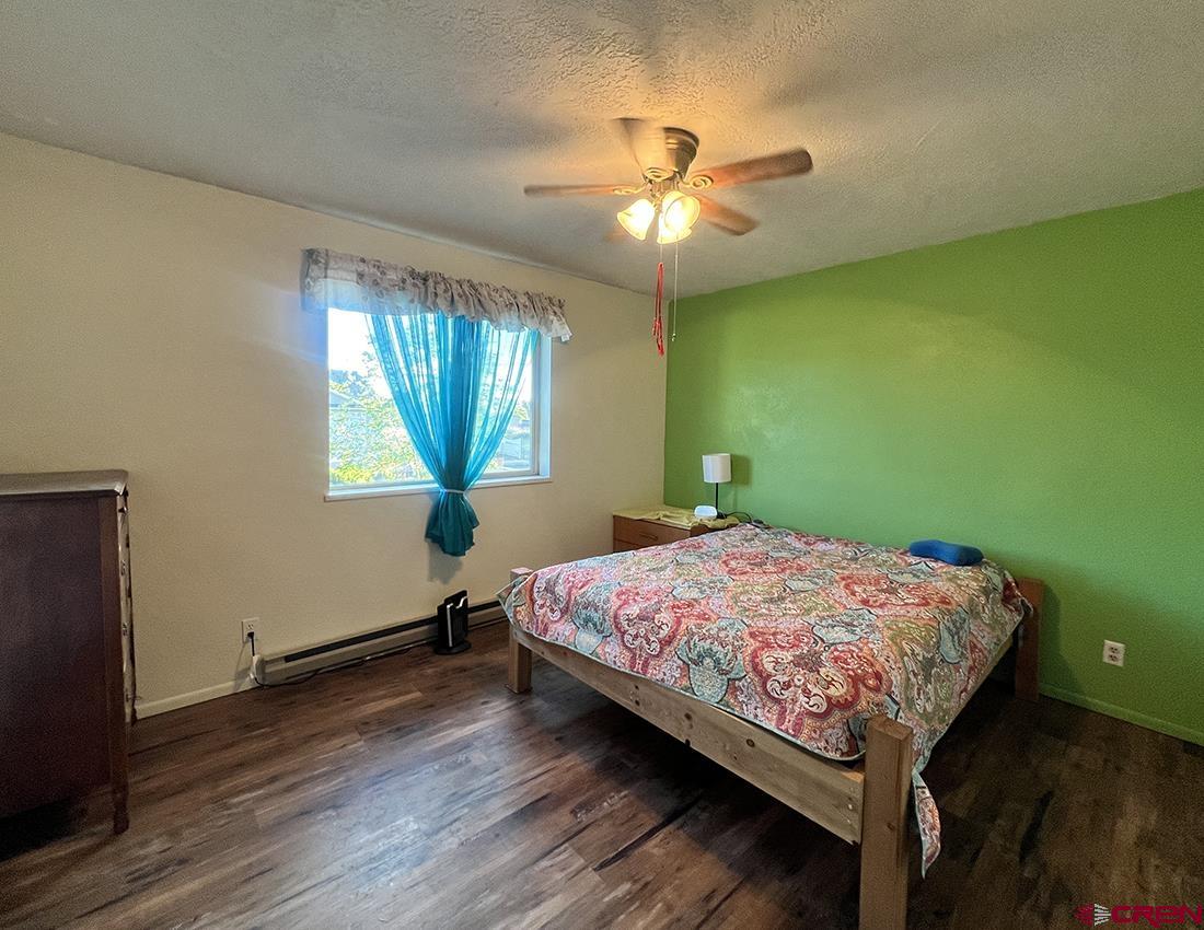 1328 Jackson Street Cortez, CO 81321 - Photo 22 of 37 a bedroom with a bed and a chandelier