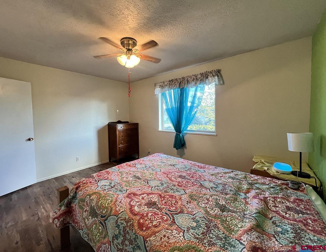 1328 Jackson Street Cortez, CO 81321 - Photo 23 of 37 a bedroom with a bed and a chandelier