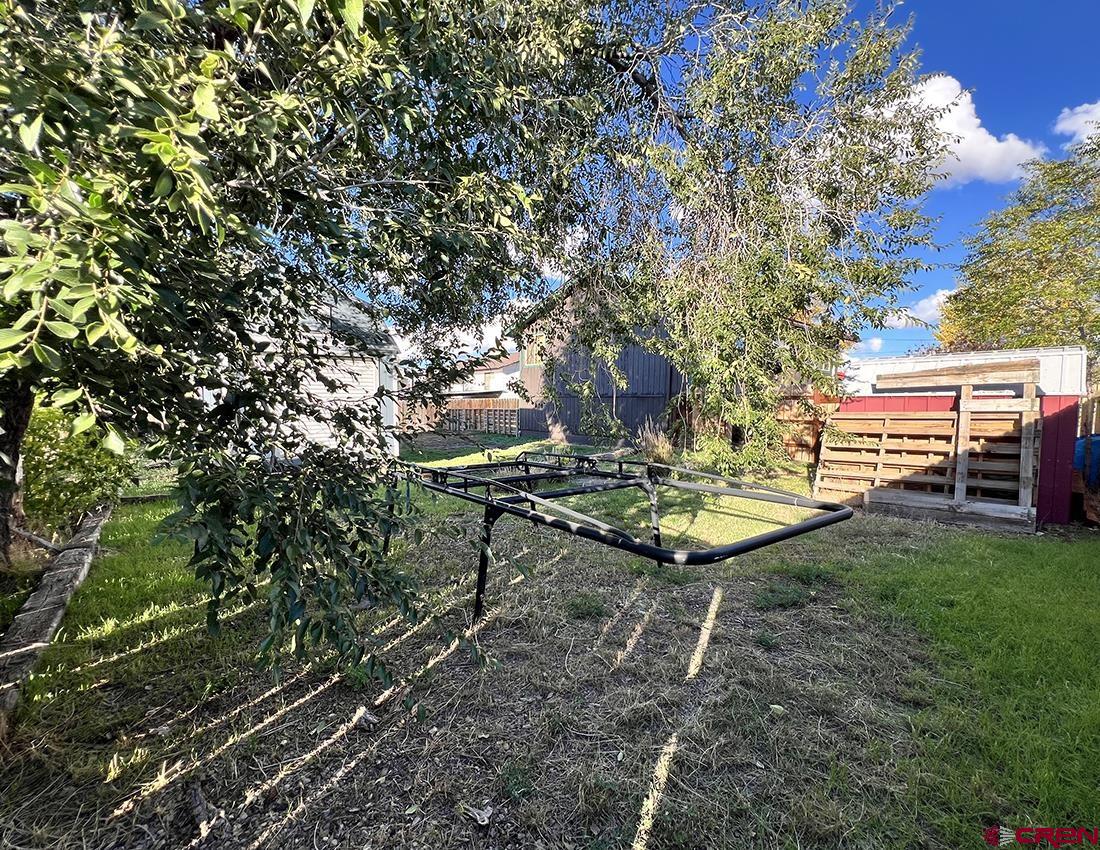 1328 Jackson Street Cortez, CO 81321 - Photo 30 of 37 a view of a backyard with table and chairs with a fire pit and a large tree
