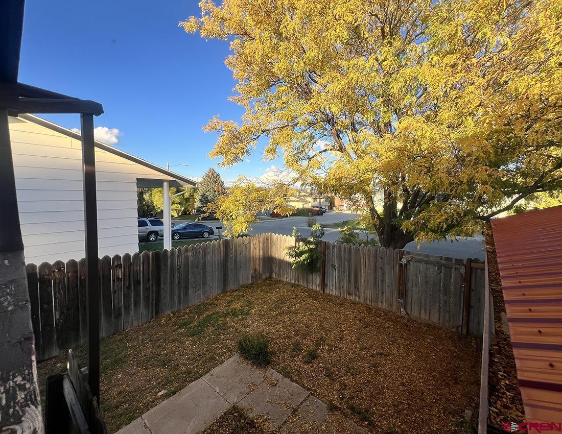 1328 Jackson Street Cortez, CO 81321 - Photo 35 of 45 a view of a backyard with wooden fence and large trees