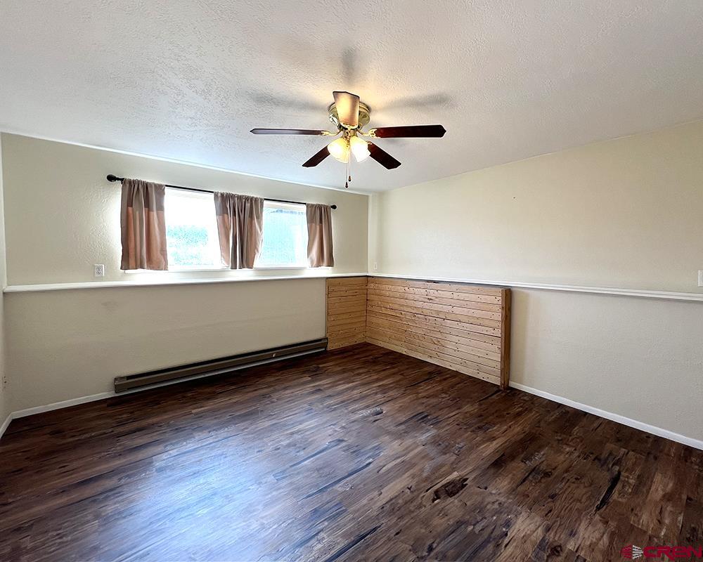 1328 Jackson Street Cortez, CO 81321 - Photo 7 of 45 a view of an empty room with wooden floor and a window