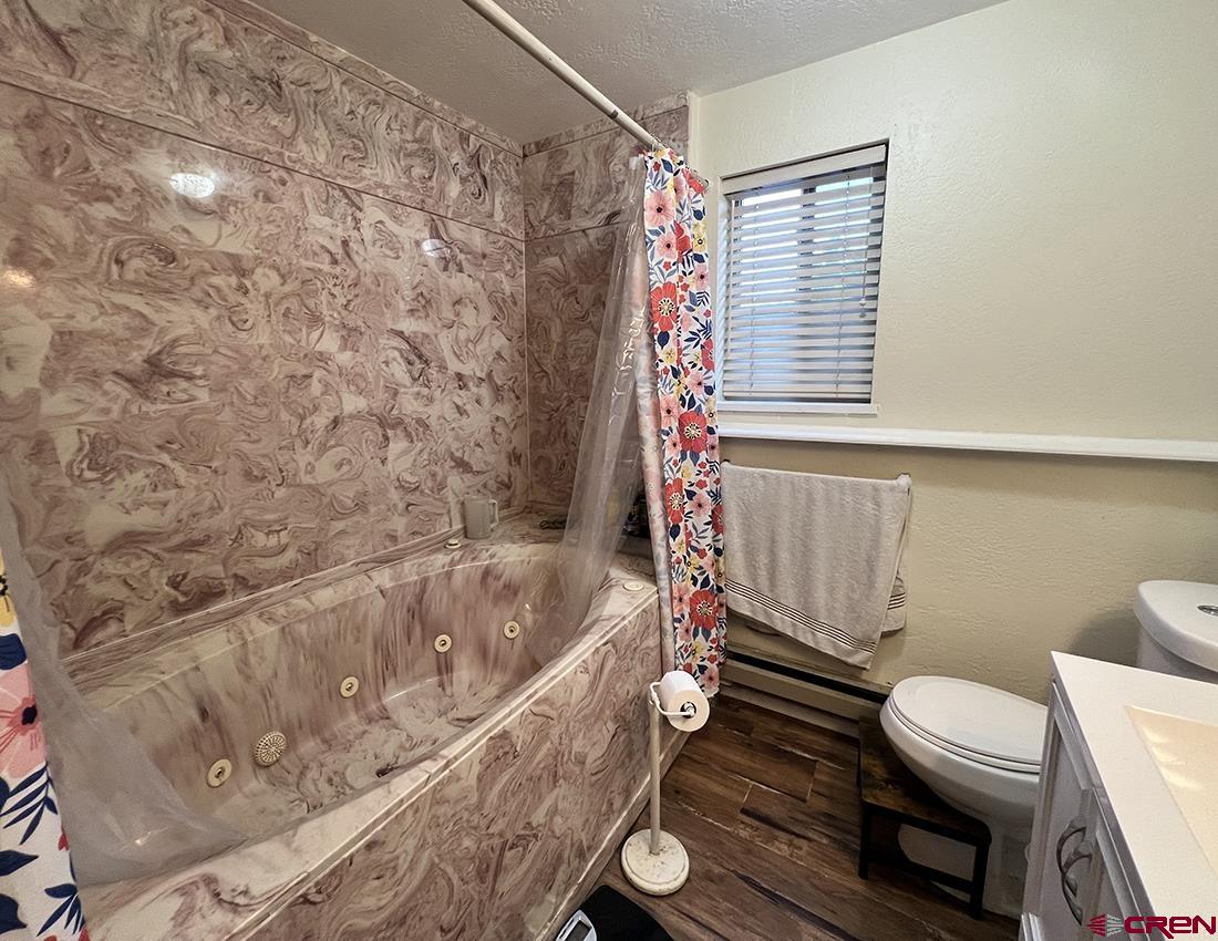 1328 Jackson Street Cortez, CO 81321 - Photo 7 of 37 a bathroom with a toilet and a bathtub