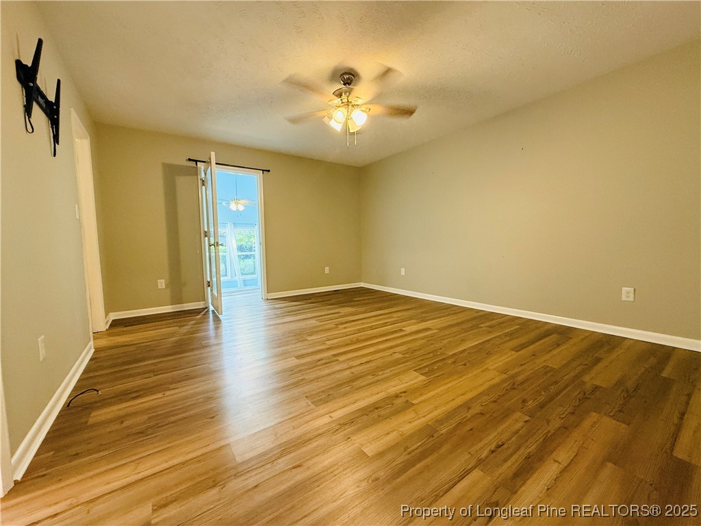300 Wedge Court Hope Mills, NC 28348 - Photo 17 of 26 a view of an empty room with wooden floor and a ceiling fan