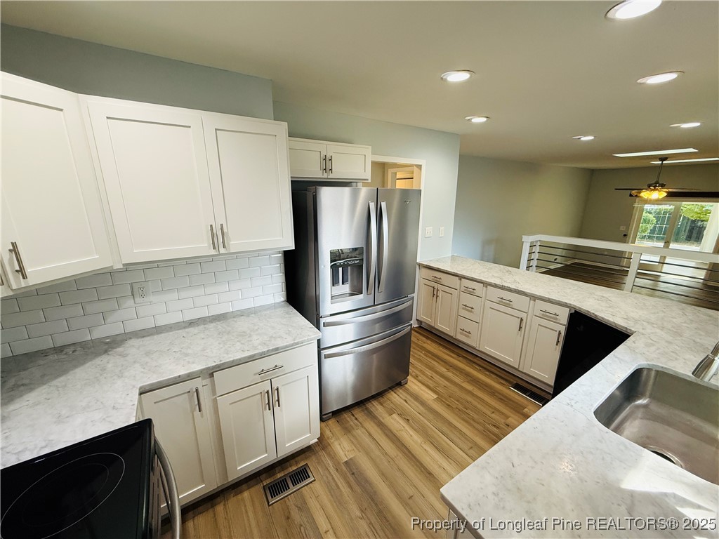300 Wedge Court Hope Mills, NC 28348 - Photo 4 of 26 a kitchen with stainless steel appliances granite countertop a refrigerator a stove and a sink with wooden floors
