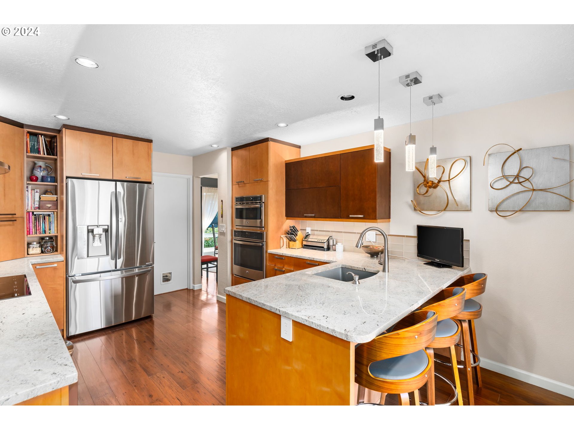 10 Condolea Drive Lake Oswego, OR 97035 - Photo 14 of 28 a kitchen with stainless steel appliances a stove a refrigerator a sink a dining table and chairs with wooden floor