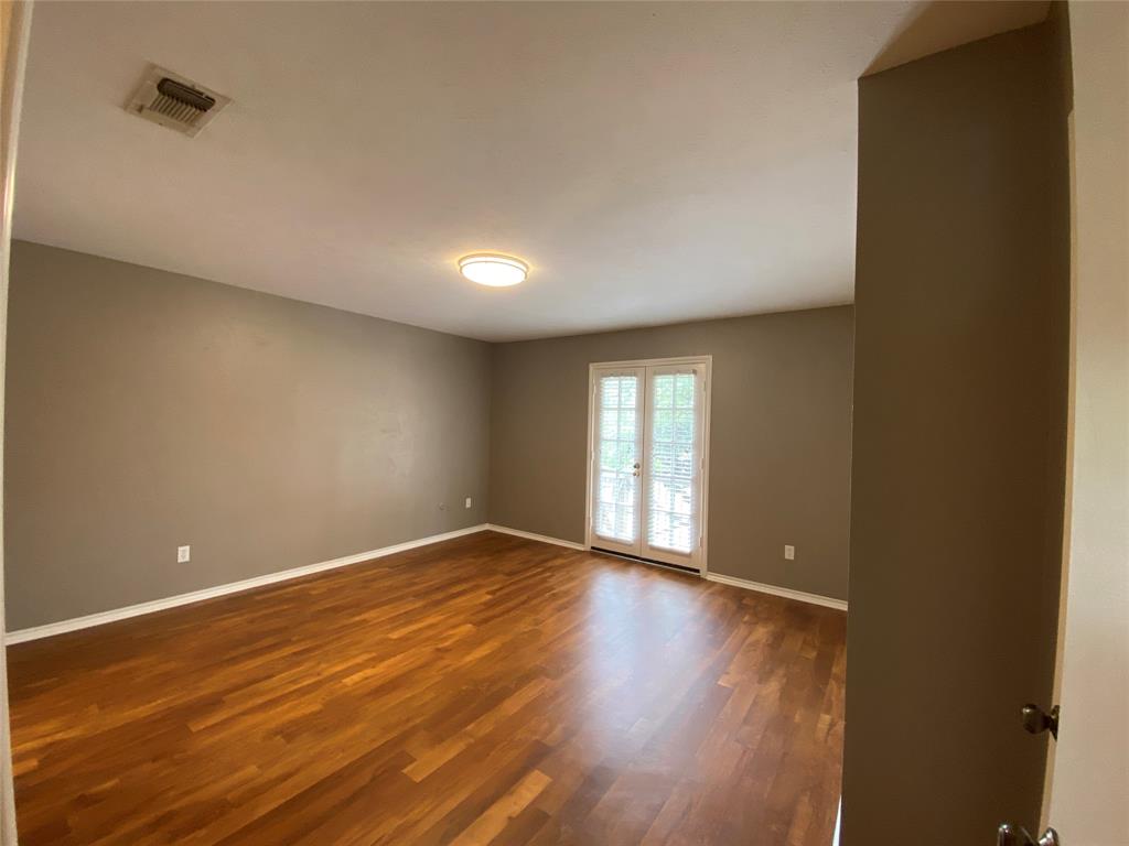 6 1 Main Place Benbrook, TX 76126 - Photo 16 of 28 a view of an empty room with wooden floor and a window