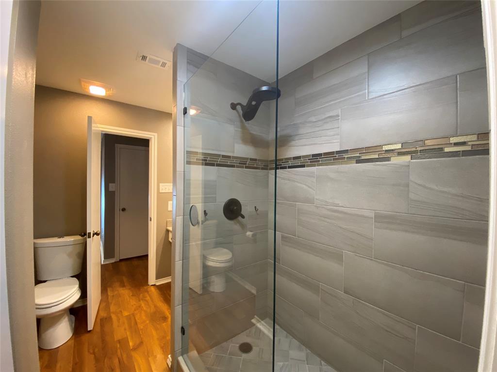6 1 Main Place Benbrook, TX 76126 - Photo 18 of 28 a bathroom with a toilet and a shower