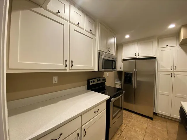a kitchen with stainless steel appliances a refrigerator sink and microwave
