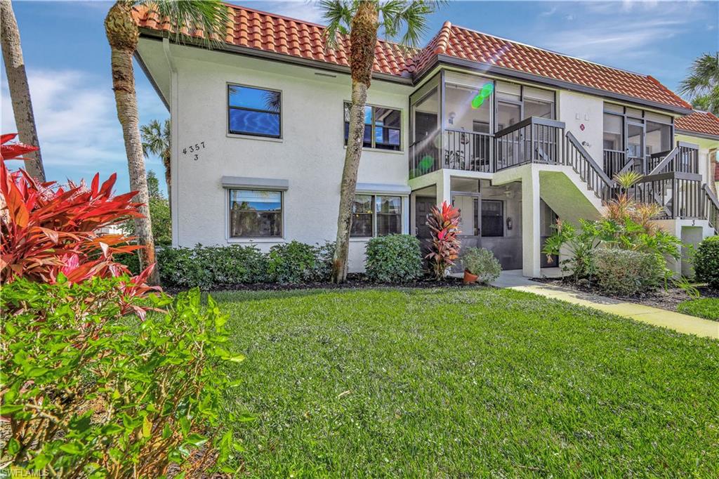 4357 27th Court Southwest, Unit 101 Naples, FL 34116 - Photo 1 of 25 front view of a house with a small yard