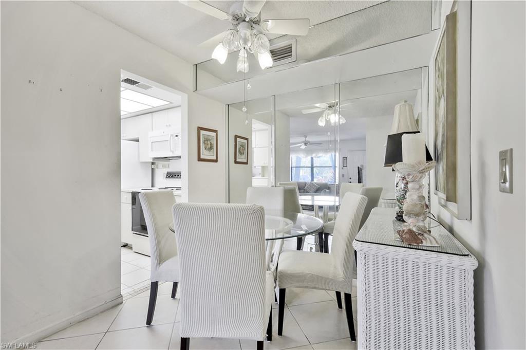 4357 27th Court Southwest, Unit 101 Naples, FL 34116 - Photo 11 of 25 a view of a dining room with furniture and chandelier
