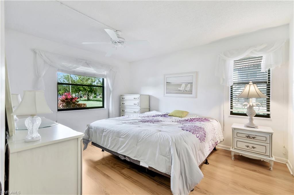 4357 27th Court Southwest, Unit 101 Naples, FL 34116 - Photo 12 of 25 a bedroom with a bed and a flat tv screen on dresser