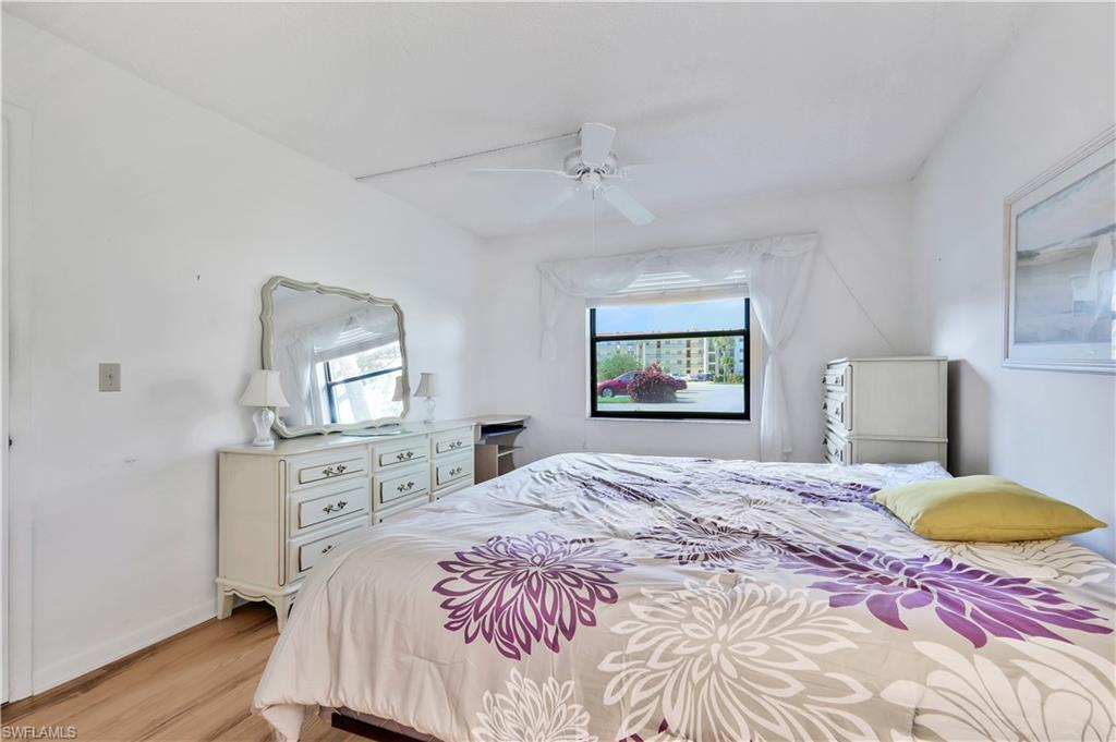 4357 27th Court Southwest, Unit 101 Naples, FL 34116 - Photo 13 of 25 a bedroom with a bed and a dresser