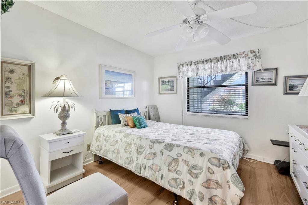4357 27th Court Southwest, Unit 101 Naples, FL 34116 - Photo 16 of 25 a bedroom with a bed and a table in it