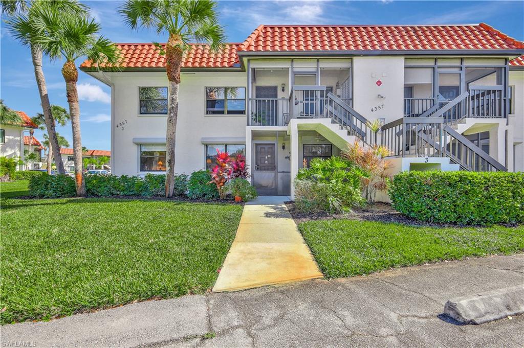 4357 27th Court Southwest, Unit 101 Naples, FL 34116 - Photo 3 of 25 a front view of a house with garden
