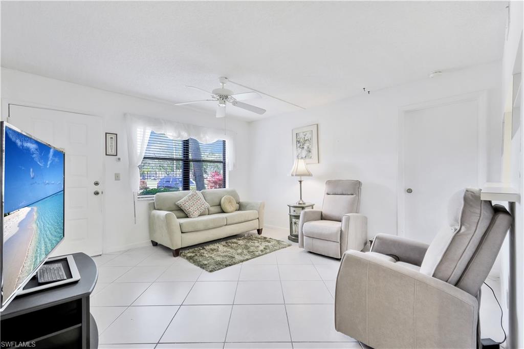 4357 27th Court Southwest, Unit 101 Naples, FL 34116 - Photo 4 of 25 a living room with furniture and a flat screen tv