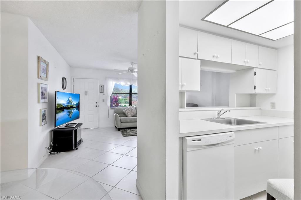 4357 27th Court Southwest, Unit 101 Naples, FL 34116 - Photo 8 of 25 a kitchen with a sink and white cabinets