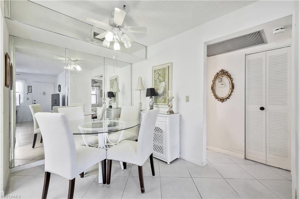 4357 27th Court Southwest, Unit 101 Naples, FL 34116 - Photo 10 of 25 a view of a dining room with furniture and a large window