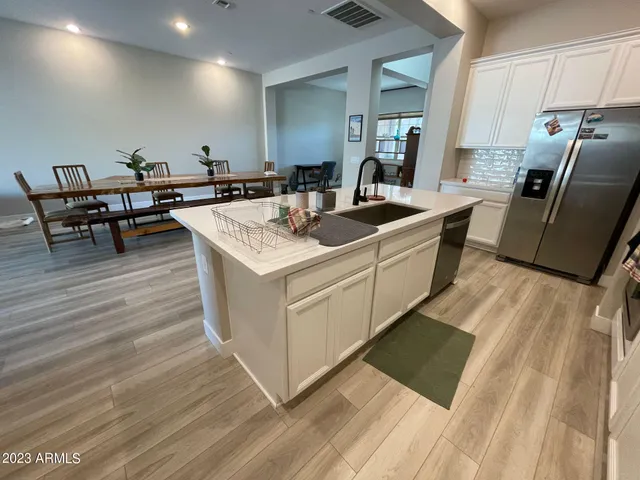a large white kitchen with a sink and a stove top oven