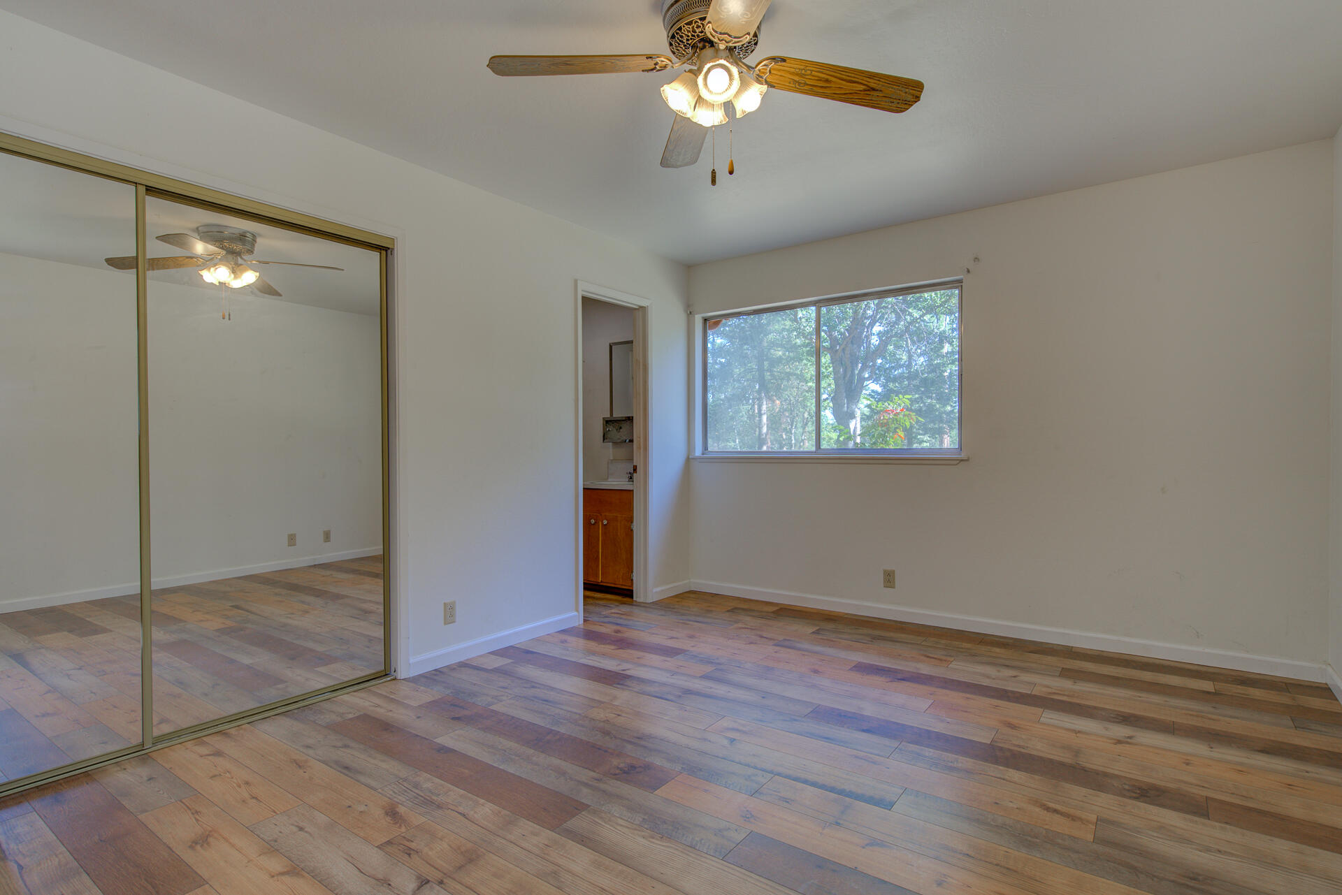 21694 Cassel Road Cassel, CA 96016 - Photo 35 of 65 an empty room with wooden floor chandelier fan and windows